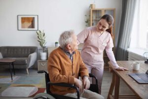 Family member and older adult share a quiet conversation in a bright assisted living room.